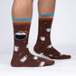 Brown socks with coffee-themed design worn by a person on a white background
