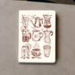 Notebook with coffee-themed illustrations on a gray surface
