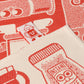 Close-up of a red and white patterned fabric with coffee-themed designs.