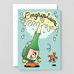 Cartoon champagne bottle character with a cartoon cork on a 'Congratulations' card against a gray background