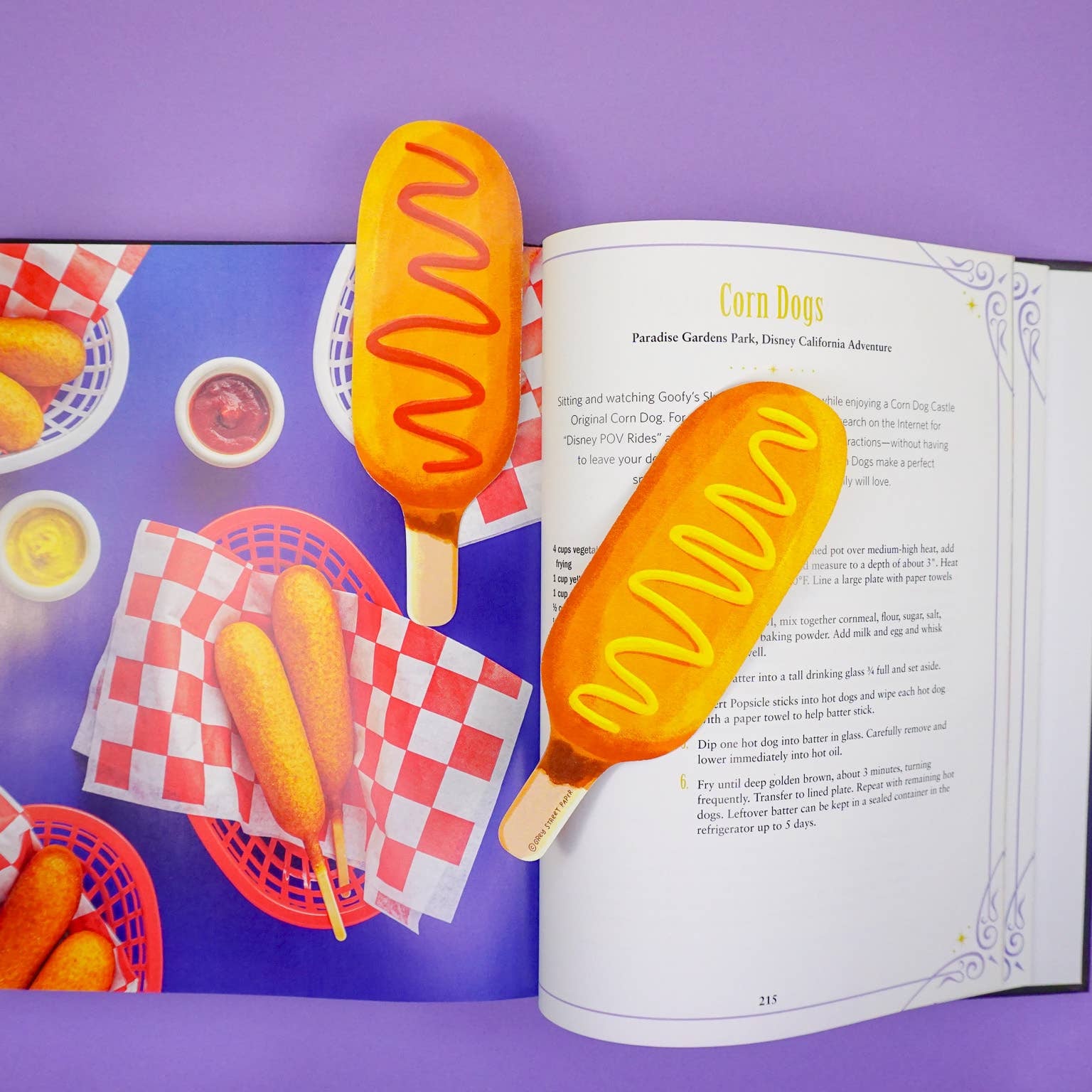 corn dog bookmarks in an open book against a purple background
