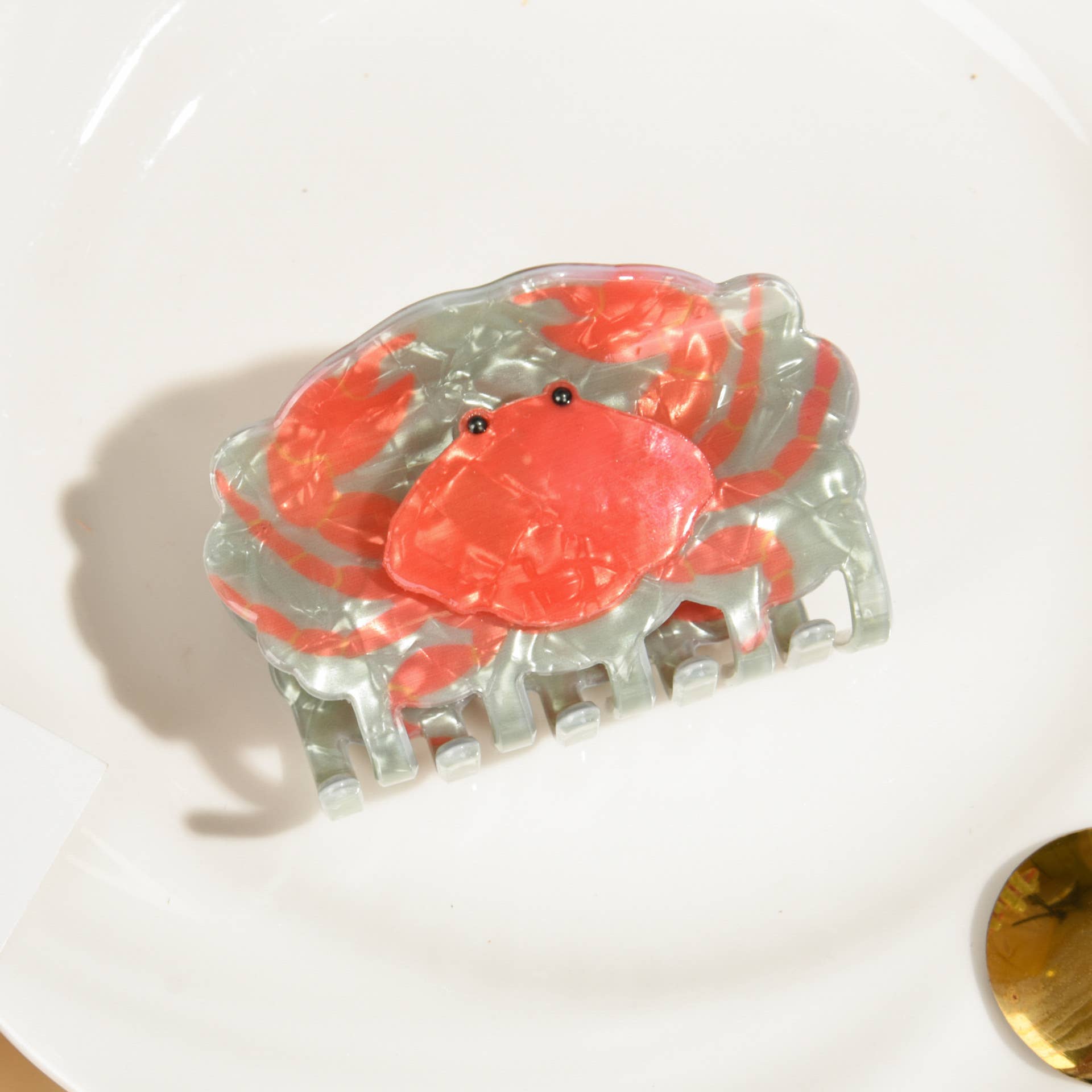Clear crab-shaped hair claw on a white surface