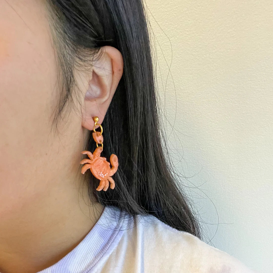 acrylic crab earrings on model 