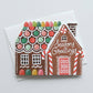 Greeting card with a die-cut gingerbread house design and 'Season's Greetings' text on a white background.