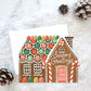 Greeting card with a gingerbread house design on a snowy background
