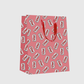 Red gift bag with Diet Coke can pattern on a light gray background