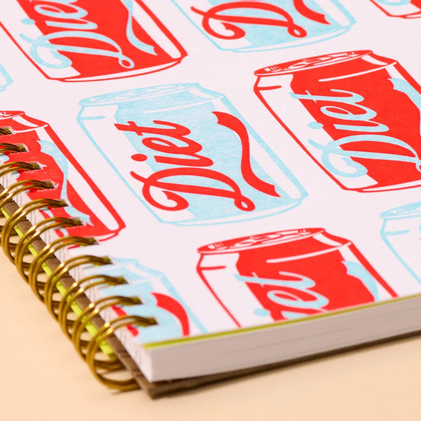 Notebook with Diet Coke can pattern on a beige background