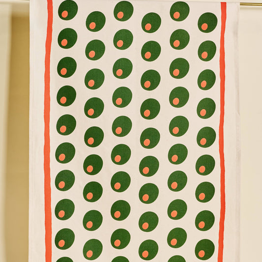 Tea towel with pimento stuffed green olives pattern on a white background with a red line border along edges