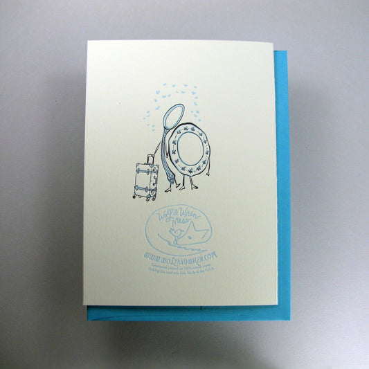 Greeting card with blue border and illustration of a dish and spoon with a suitcase, on a gray background