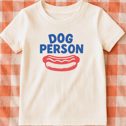 White t-shirt with 'DOG PERSON' and a hot dog graphic on a red and white checkered background