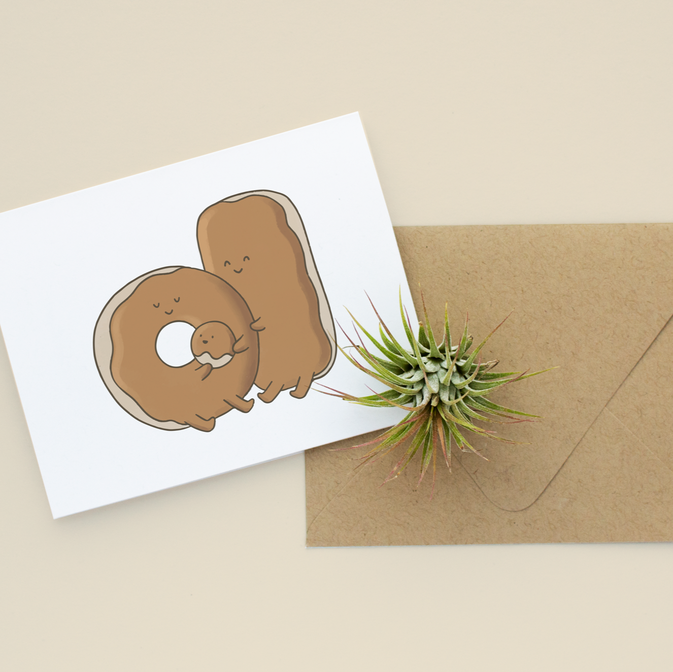 Greeting card with a donut illustration and a brown envelope on a beige background