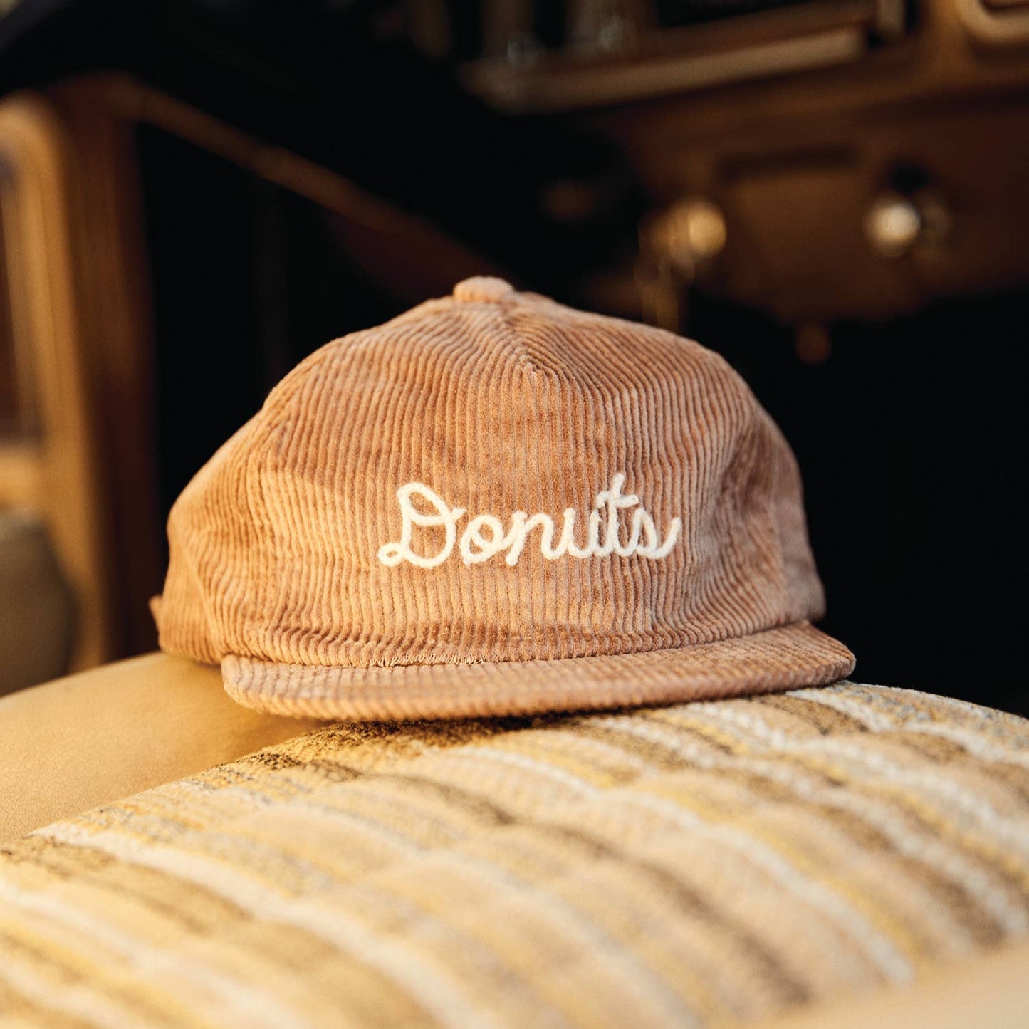 corduroy hat with chainstitched text that reads "Donuts" 