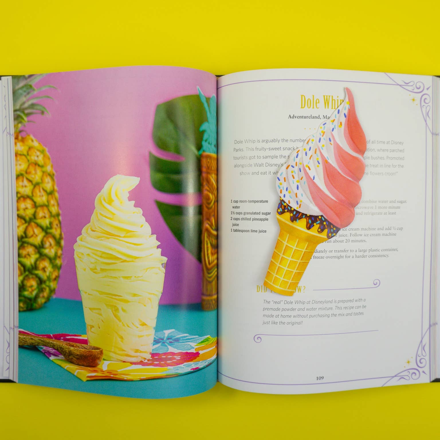 Open book showing an ice cream cone bookmark on a page featuring a pineapple and pineapple soft serve on a yellow background