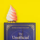 Book titled 'The Unofficial' with a soft-serve ice cream bookmark in it on a yellow background