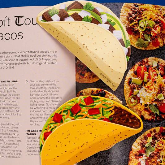 Illustrations of tacos bookmarks on a magazine page with text about tacos.