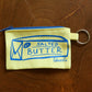 Another front view of salted butter zipper pouch on wooden table 