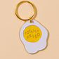 Enamel keychain of an egg that says Totally Fried.