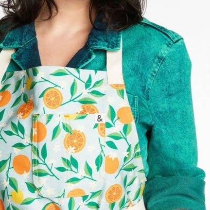 Apron with Backyard Oranges print on blue background.