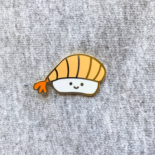 ebi sushi enamel pin with a smiley face on it 