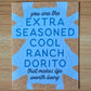 Card with blue text featuring a humorous message, "you are the extra seasoned cool ranch dorito that makes life worth living" on a wooden surface.