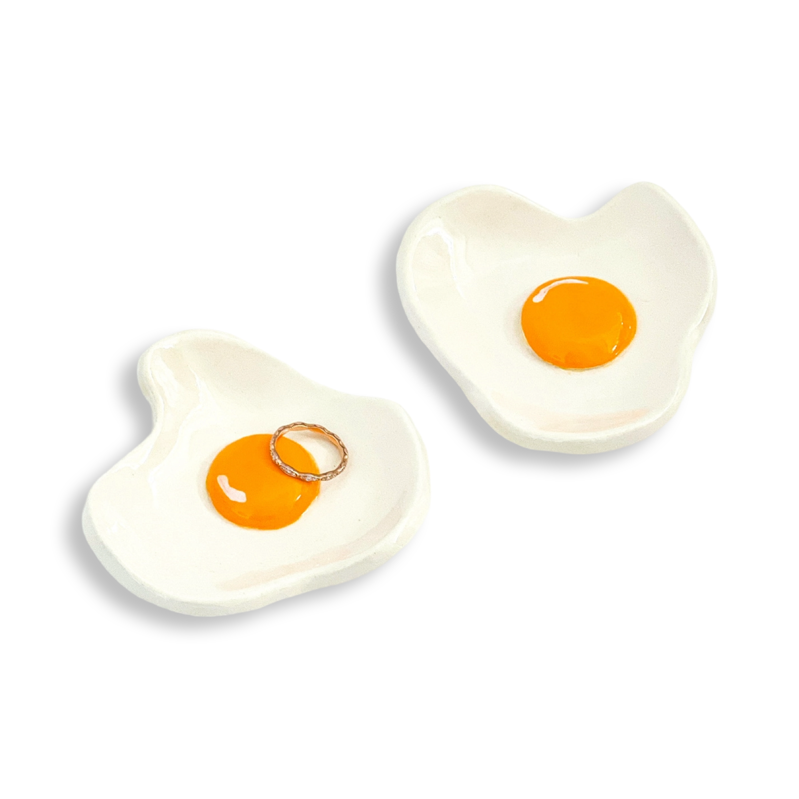 Two egg-shaped ceramic plates with egg designs on a white background