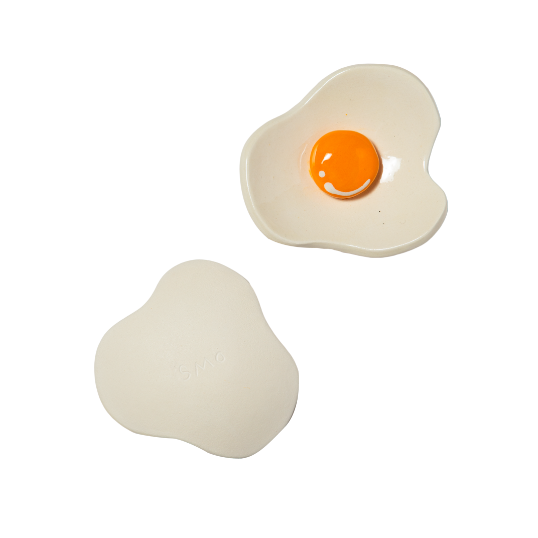 Two ceramic egg-shaped dishes on a white background