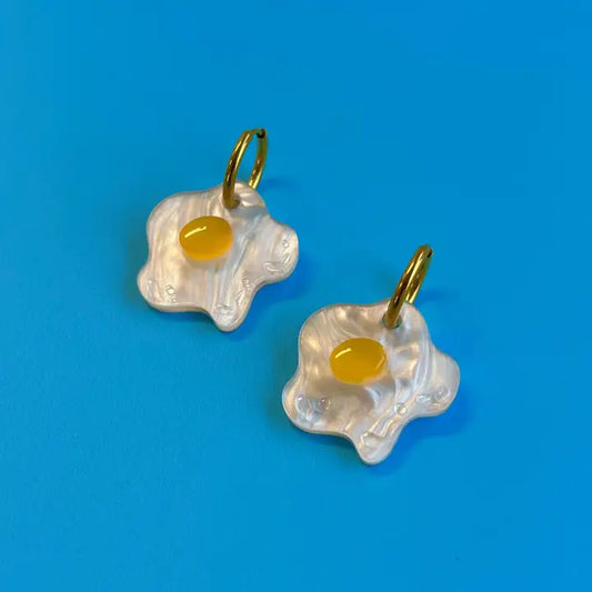 Acrylic sunny side up egg earrings on blue background 