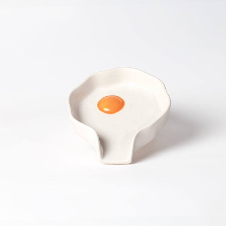 Ceramic spoon rest shaped like a cracked/fried egg.