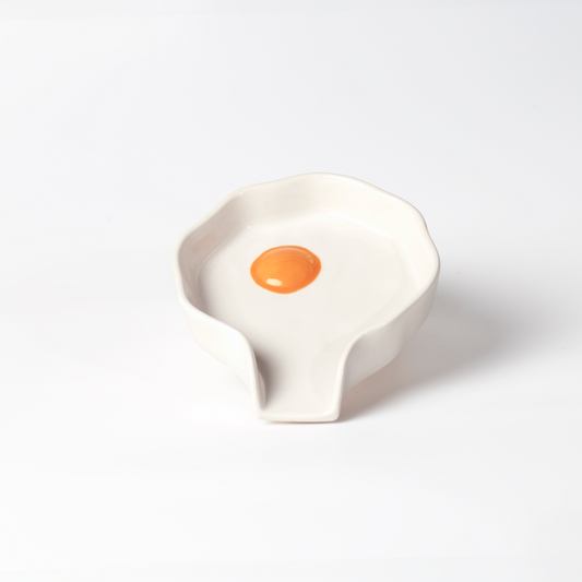 Ceramic spoon rest shaped like a cracked/fried egg.