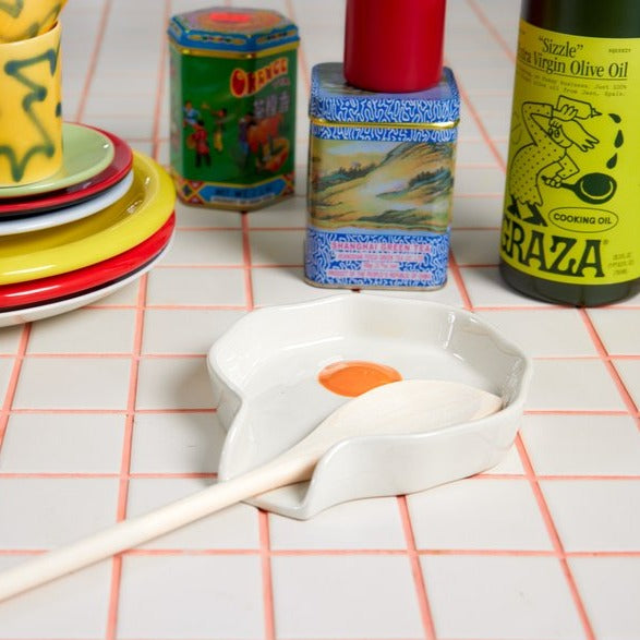 Egg Spoon Rest shown on counter with wood spoon and kitchen items.