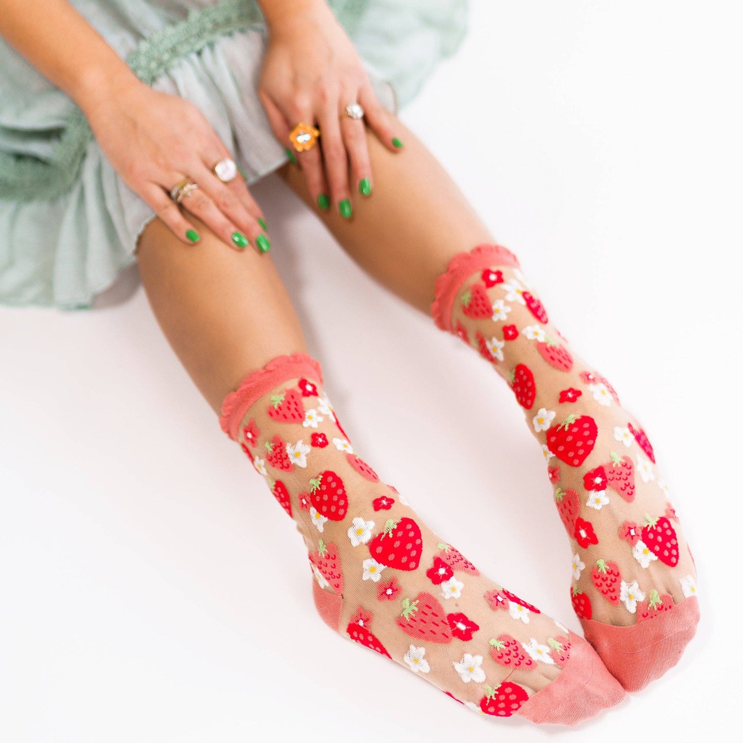 Pink and red strawberry sheer crew socks on model 