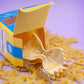 Hair claw made to look like a farfalle pasta. Pictured here coming out of box packaging, on a bed of dried farfalle pasta