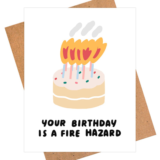 Birthday greeting card with a cake and lots of candles burning on it. Text reads "Your birthday is a fire hazard" 