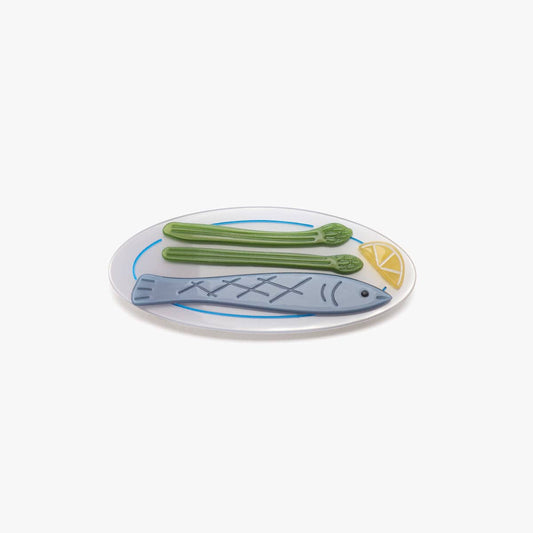 Hair clip with fish design and green asparagus on a white background