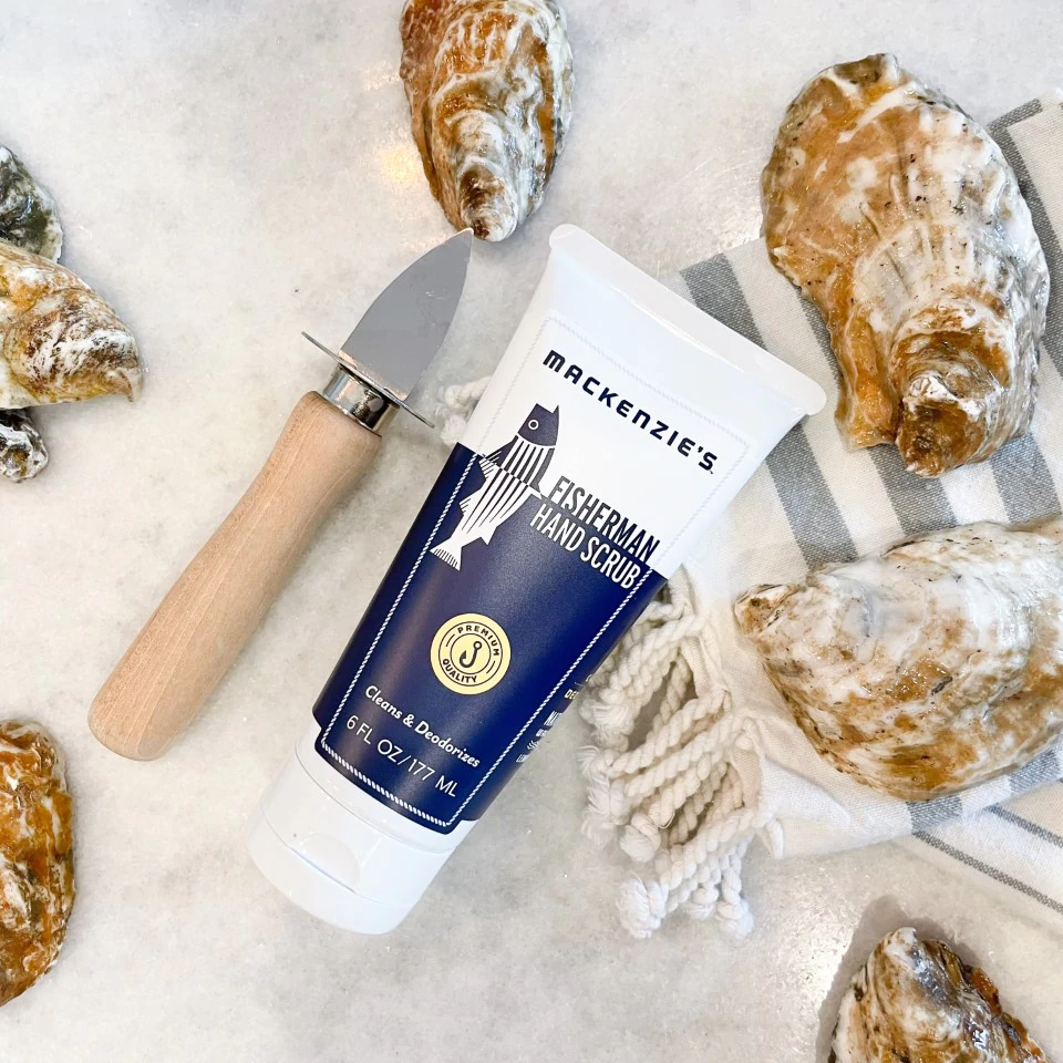 a hand scrub in a squeeze bottle that cleans and deodorizes hands, pictured next to oysters and a shucking knife 