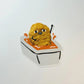 Fried chicken nugget in a sauce container with a face on a white background