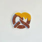 Sticker of a pretzel with cheese on a white background