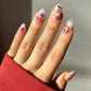 Hand with colorful nail art against a neutral background