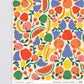 close up of the sheet of gift wrap with various fruits on it including bananas, apples, grapes, watermelon, cherries, oranges, lemons and peaches 