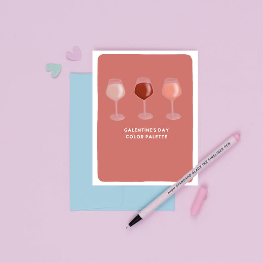Card with wine glass illustrations and 'Galentine's Day Color Palette' text on a pink background with a pen.