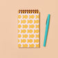 goldfish pocket notebook with pen placed next to it for sizing 