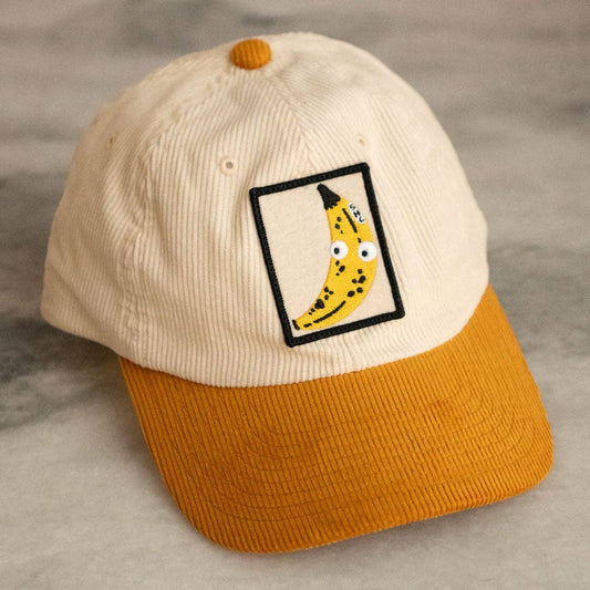 Cap with a banana graphic patch on a neutral background