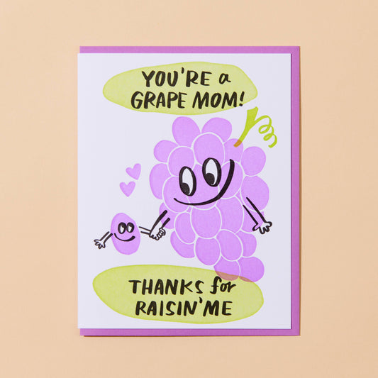 card with an illustrated grape bunch holding an illustrated, single raisin's hand. Text reads "You're a grape mom! Thanks for raisin' me" 