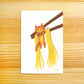 A vertical art print featuring a cute illustration of an orange tabby cat hanging from brown chopsticks with yellow noodles, displayed on a light wood grain background.