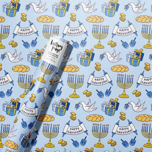 Gift wrap with Hanukkah-themed design featuring menorahs, dreidels, and 'Happy Hanukkah' text on a blue background.