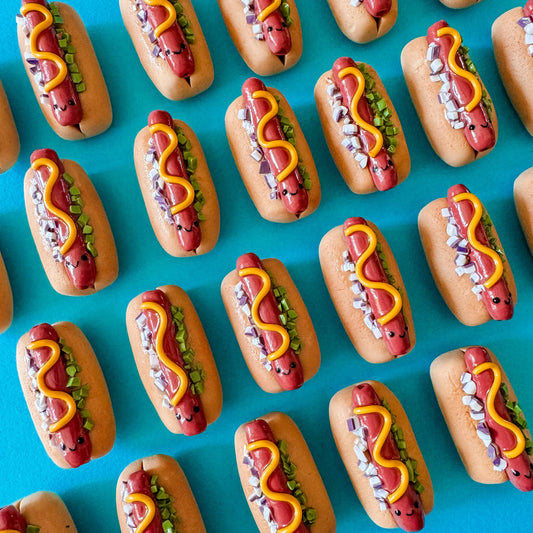 mini smiley faced hot dog magnet with a squiggle of mustard, chopped onions and relish on it