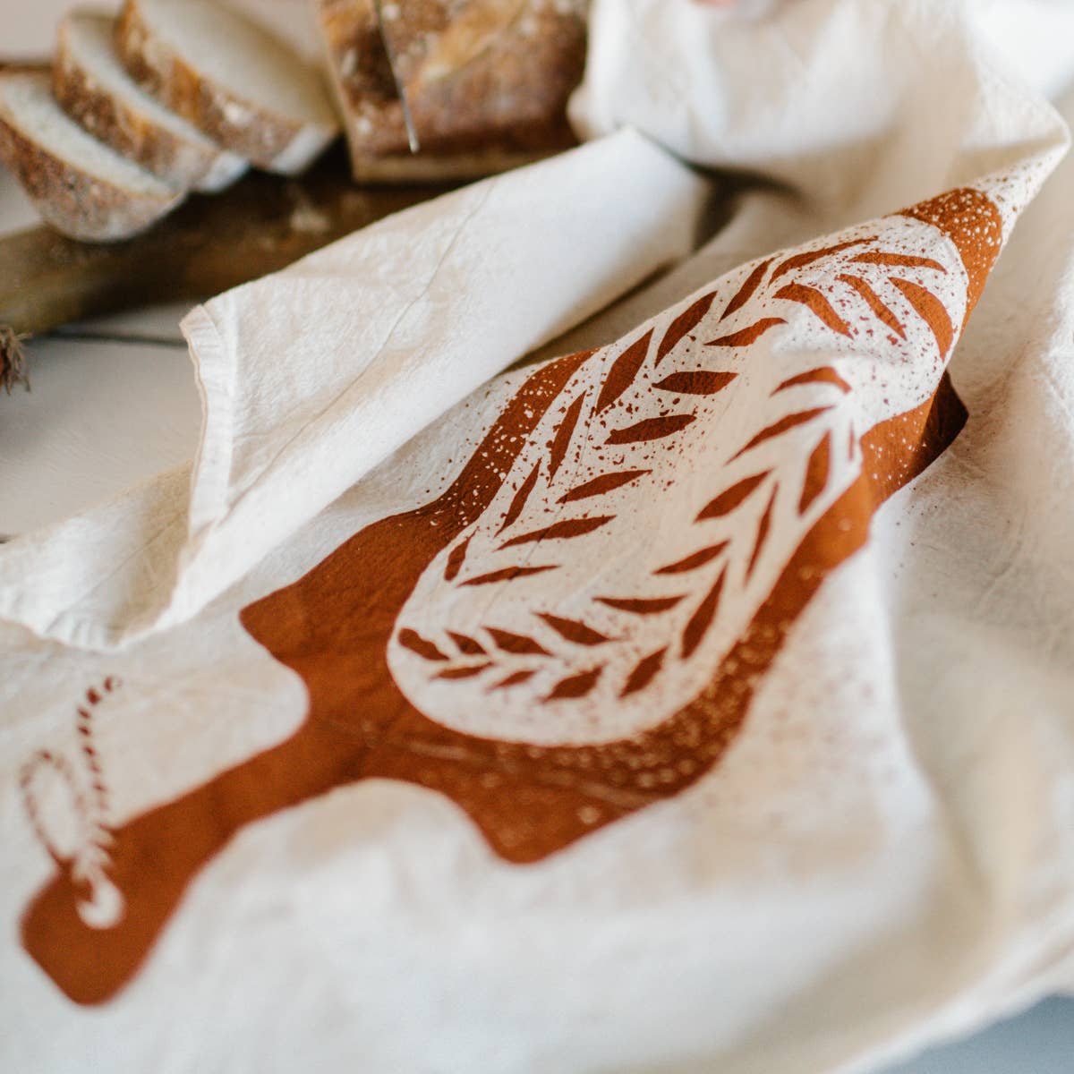 kitchen towel designed with a loaf of bread on a bread board -- close up view 