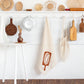 kitchen towel designed with a loaf of bread on a bread board hanging on a peg 