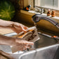 the reusable bread pattern kitchen sponge cloth being run under water to soften 