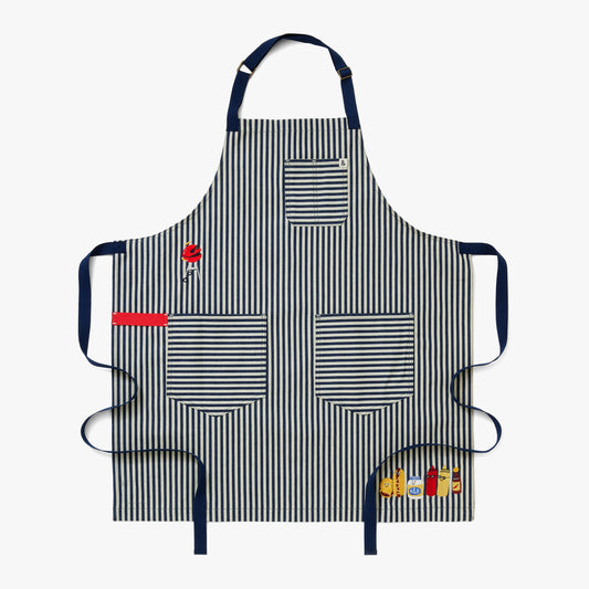 Palm striped apron body, navy straps, a red towel loop, and delectable embroidery featuring a charcoal grill, hamburger, hotdog, mayo, ketchup, mustard, and hot sauce.